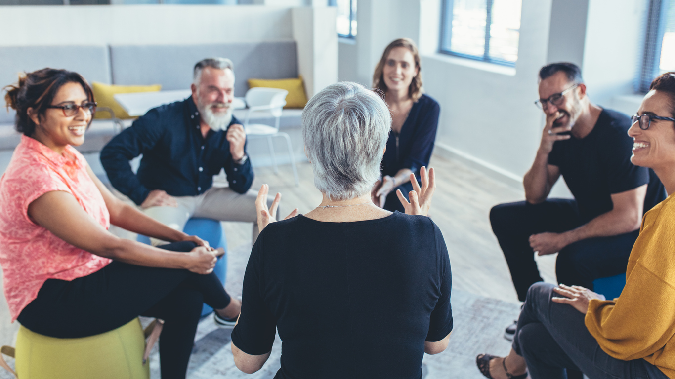 men-and-women-sitting-in-a-circle-discussing