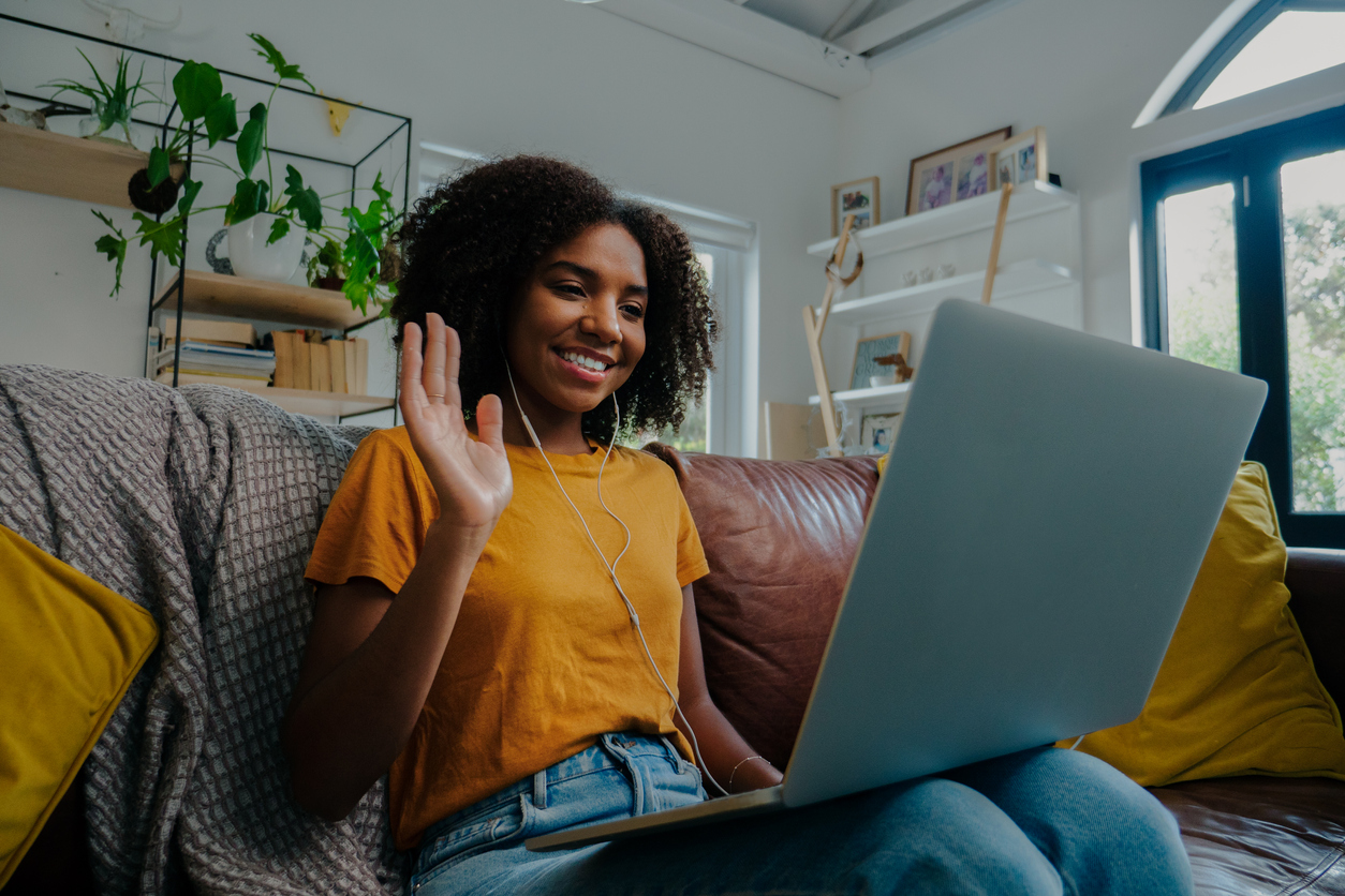 teen girl on laptop video call waving