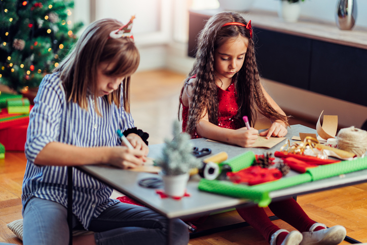 two girls writing holiday cards